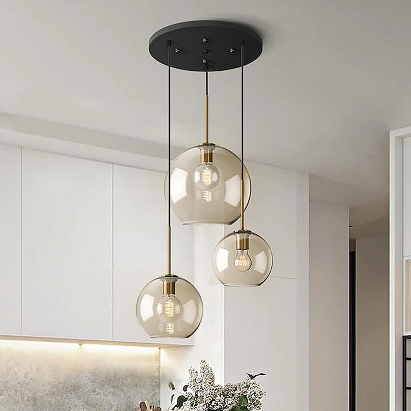 Eenvoudige hangverlichting met 3 lampen en amberkleurige glazen kap Zwarte ronde hanger met meerdere lampen Clearhalo