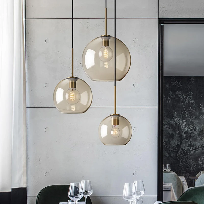 Eenvoudige hangverlichting met 3 lampen en amberkleurige glazen kap Zwarte ronde hanger met meerdere lampen Clearhalo