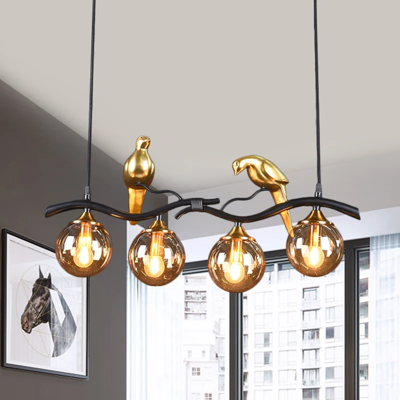 Takje Island hanglamp postmodern ijzer 4-lichts zwart/gouden hanglamp met amberkleurige bolglazen kap en vogeldeco Clearhalo